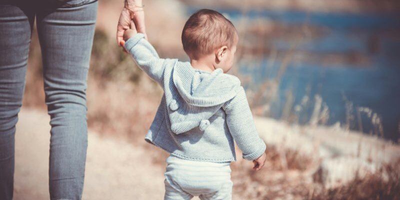 Toddler walking with mother